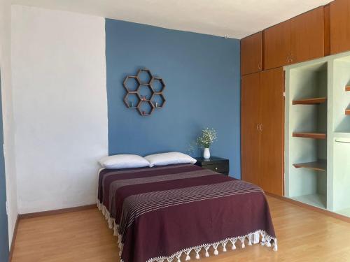 a bedroom with a bed with a blue wall at Casa Camacho in Oaxaca City