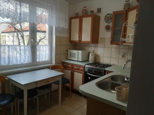 uma cozinha com um lavatório e um fogão forno superior em Mieszkanie w Centrum em Szczytno