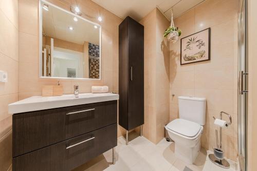 Un baño con inodoro, lavabo y espejo. en Avanti Museo, con mucho encanto!, en Sevilla