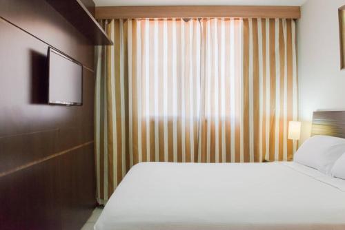 a hotel room with a bed and a television at Monumental Nobile- Apart hotel Central in Brasilia
