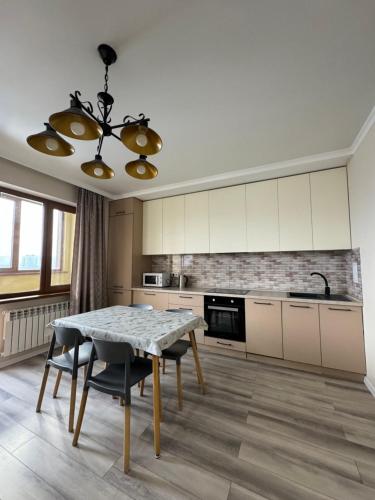 a kitchen with a table and chairs in a room at VIP apartments arbat mega in Almaty