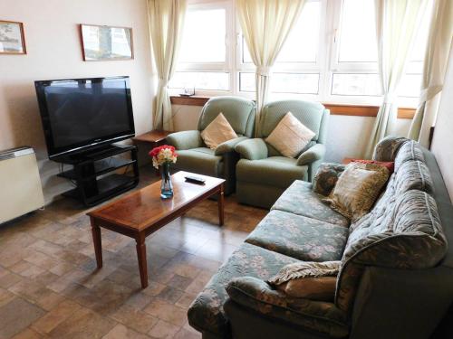 a living room with a couch and a tv at Quirky Retro 2 bed Apt in Anniesland West End in Glasgow