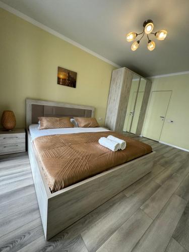 a bedroom with a large bed with two towels on it at VIP apartments arbat mega in Almaty