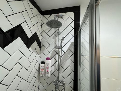 a bathroom with a shower with white tiles at Apartamento Medina-Azahara in Córdoba