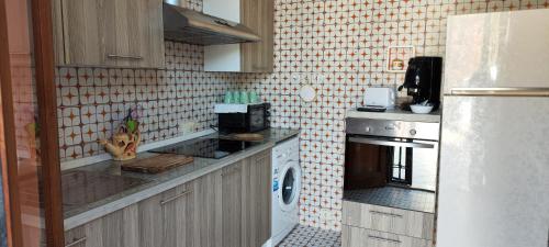 a kitchen with a refrigerator and a stove top oven at Villa Vera in Fontane Bianche