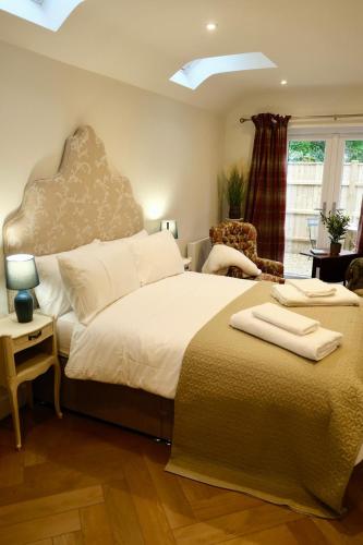 a bedroom with a large bed and a chair at Barton Hollow in Barton on Sea