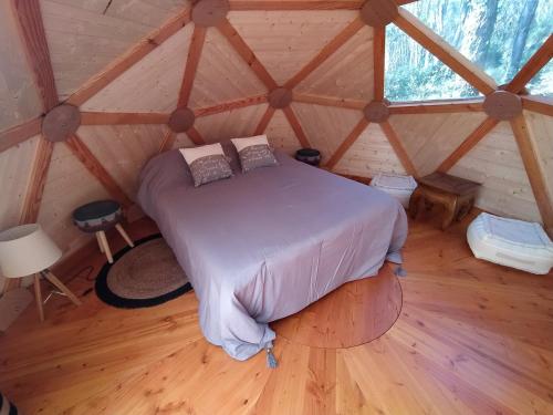 sypialnia z łóżkiem w drewnianym pokoju w obiekcie La Maison de Tari w mieście Vitrac