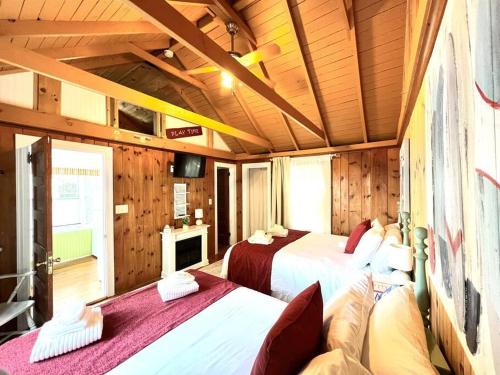 2 camas en una habitación con paredes de madera en Cottage 11 - 1 Bed / 1 Bath w/ Private Courtyard, en Wolfeboro
