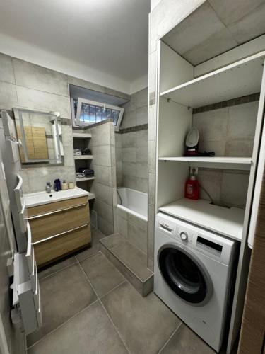 een kleine badkamer met een wasmachine bij Les Copains d'Abord in Nîmes