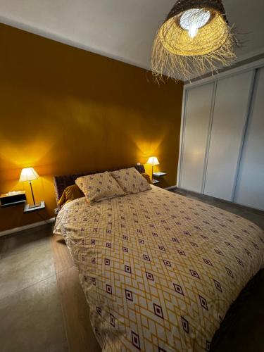 una camera con letto e lampadario a braccio di Les Copains d'Abord a Nîmes