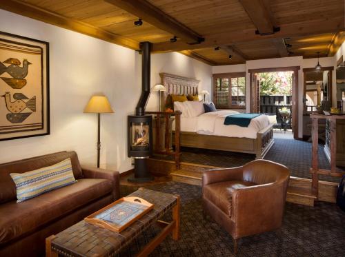 a bedroom with a bed and a couch and a chair at Rancho Caymus Inn in Rutherford