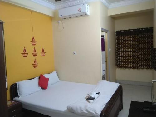 a room with a white bed with a red pillow at The Coco Inn Near South City Mall by Urban in Kolkata