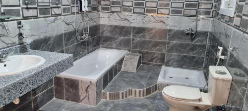 a bathroom with a tub and a toilet and a sink at DREAM ISLAND Hotel in Luxor