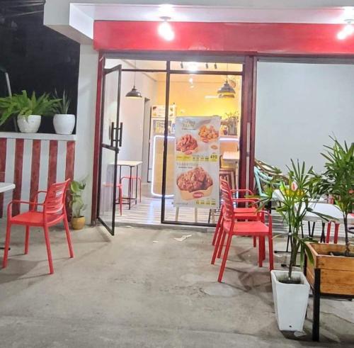 Omma's Beach House في ليان: مطعم فيه كراسي حمراء وطاولات ونافذة