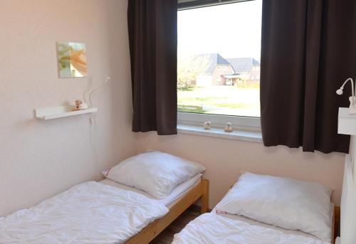 two beds in a room with a window at Fewo 91 WHG A 14 in Burhave in Burhave