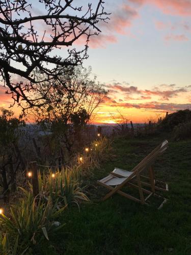 una silla sentada en el césped con una puesta de sol en Vulkán Nyúlontúl, en Mencshely