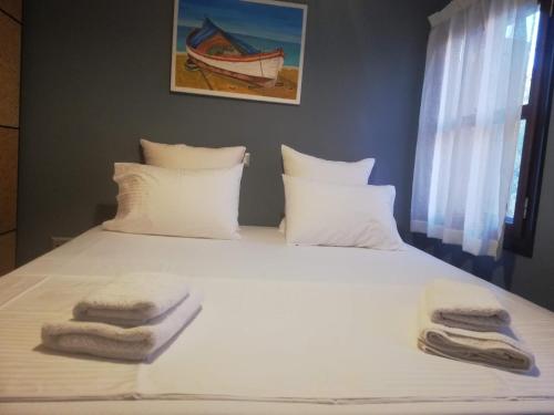 um quarto com uma cama com toalhas em Kavos House em Meyisti