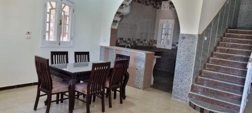 a dining room with a table and chairs and a staircase at DREAM ISLAND Hotel in Luxor