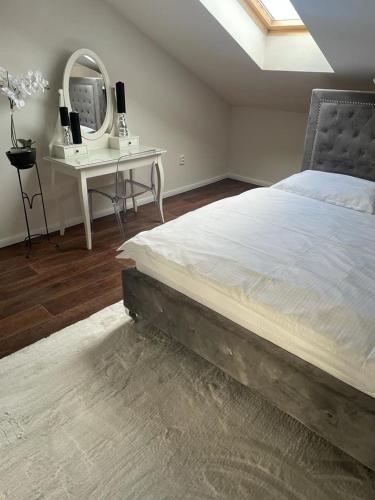 1 dormitorio con cama y escritorio con espejo en Apartmán, en Kadaň