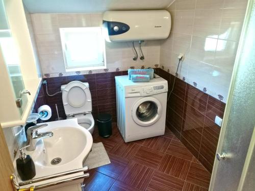 małą łazienkę z pralką i umywalką w obiekcie Apartmani Kenova 4 w mieście Herceg Novi
