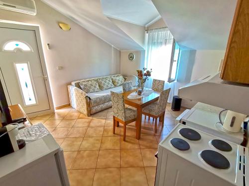 eine Küche und ein Wohnzimmer mit einem Tisch und einem Sofa in der Unterkunft Apartmani Kenova 4 in Herceg-Novi
