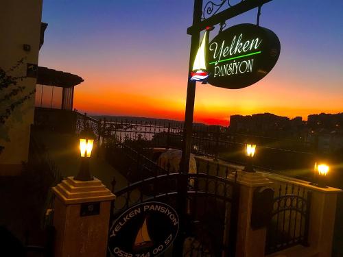 a sign for a restaurant with a sunset in the background at YELKEN PANSİYON Sinop in Sinop