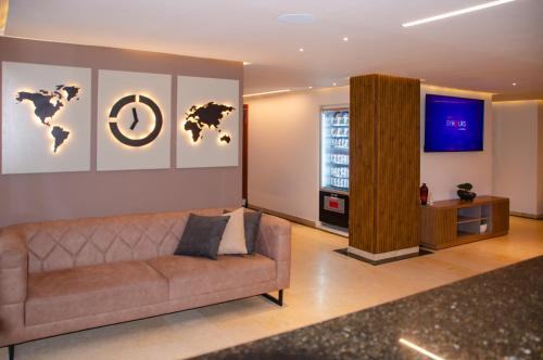 a living room with a couch and a television at Hotel ByHours Las Américas in Bogotá