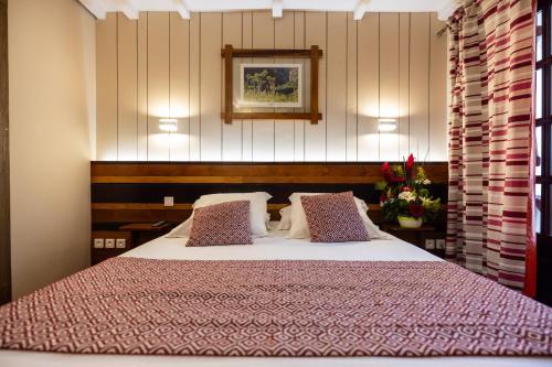 a bedroom with a large bed with pillows at Le Vieux Cep in Cilaos