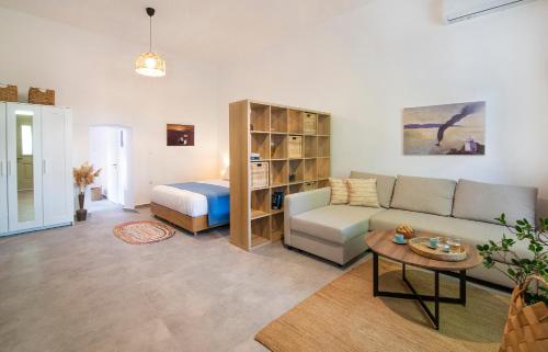 una sala de estar con un sofá y una cama en Chora Aegina's Apartments, en Aegina Town