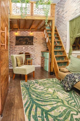 a living room with a staircase and a brick wall at Miami Tiny Vintage Cottage in Hialeah