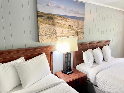 pokój hotelowy z 2 łóżkami i zdjęciem plaży w obiekcie Elk Rapids Lakeshore Inn w mieście Elk Rapids