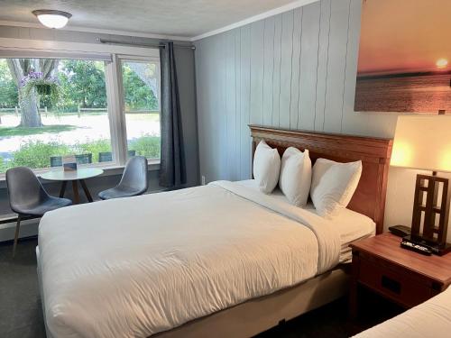 a hotel room with a bed and a window at Elk Rapids Lakeshore Inn in Elk Rapids