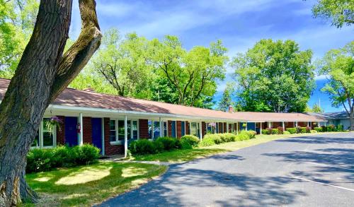 a building with a tree in front of it at Elk Rapids Lakeshore Inn in Elk Rapids