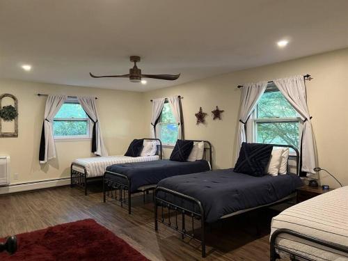 a bedroom with three beds and two windows at Melvin Village - 5 Bed/3 Bath - Lake Winnipesaukee in Tuftonboro