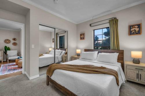 ein großes Schlafzimmer mit 2 Betten und einem Spiegel in der Unterkunft Stylish in Sunny Santa Monica walk to Beach & Pier in Los Angeles