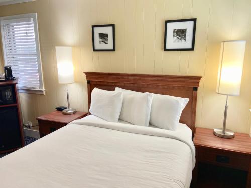 a bedroom with a large white bed with two lamps at Elk Rapids Lakeshore Inn in Elk Rapids