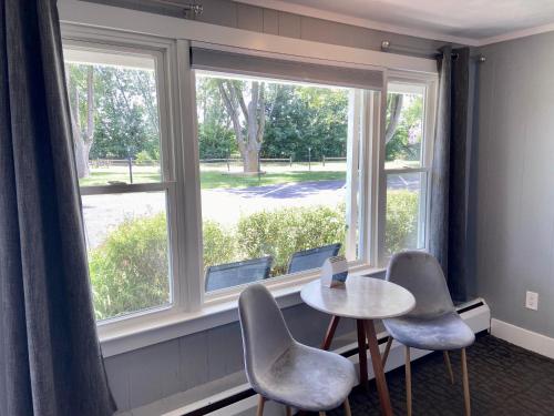 a room with a table and chairs and a window at Elk Rapids Lakeshore Inn in Elk Rapids