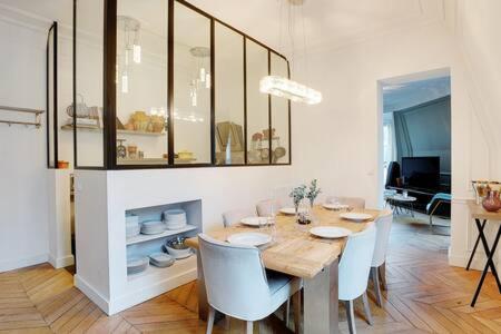 une salle à manger avec une table et des chaises en bois et une salle à manger dans l'établissement Appartement chic au cœur de Paris Montorgueil 2BDR, à Paris
