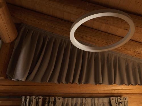 a circular light hanging from a ceiling with curtains at Hotel Haus Michaela in Sappada