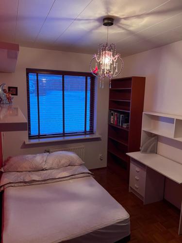 a bedroom with a bed and a chandelier at Stylish 4BD spacious, great view. in Reykjavík