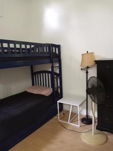 1 dormitorio con litera, mesa y ventilador en Lenny's Cooperative Hostel en Clearwater