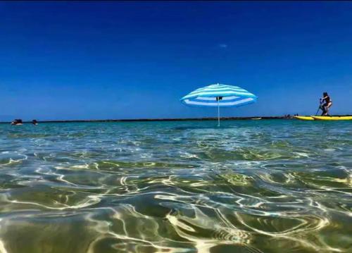 una playa con una sombrilla en el agua en Flat beira mar no Manihi - Muro Alto, en Ipojuca