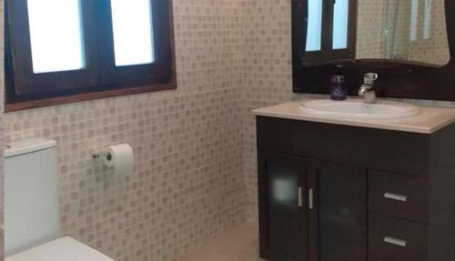 W łazience znajduje się umywalka, toaleta i lustro. w obiekcie Apartamentos "Casa Melé" 2, Parking privado opcional w mieście Lleida