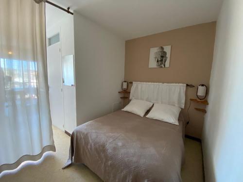 une chambre avec un lit et une fenêtre dans l'établissement Appartement cosy proche thermes à Balaruc-les-Bains, animaux admis - FR-1-503-92, à Balaruc-les-Bains
