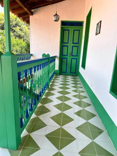 a hallway with a green door and a tiled floor at Casa Cedrela Hotel Boutique by HMC -Cauca Viejo- Mayores de 14 años in Jericó