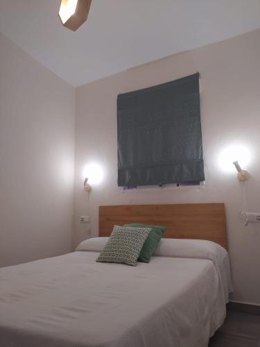 a bedroom with a bed with a television on the wall at LA FUENTE 2 in El Gastor