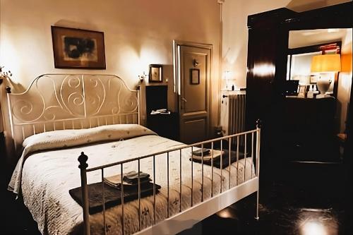 sypialnia z łóżkiem i lustrem w obiekcie Rooms by Anna we Florencji