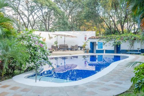 a swimming pool in a yard with a house at Hotel Aeropuerto in Alajuela