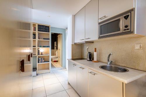a kitchen with a sink and a microwave at Arthome Acropolis View in Athens