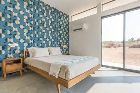 1 dormitorio con 1 cama con pared azul en Desert Diamond- Joshua Tree Cowboy Pool and Spa, en Yucca Valley